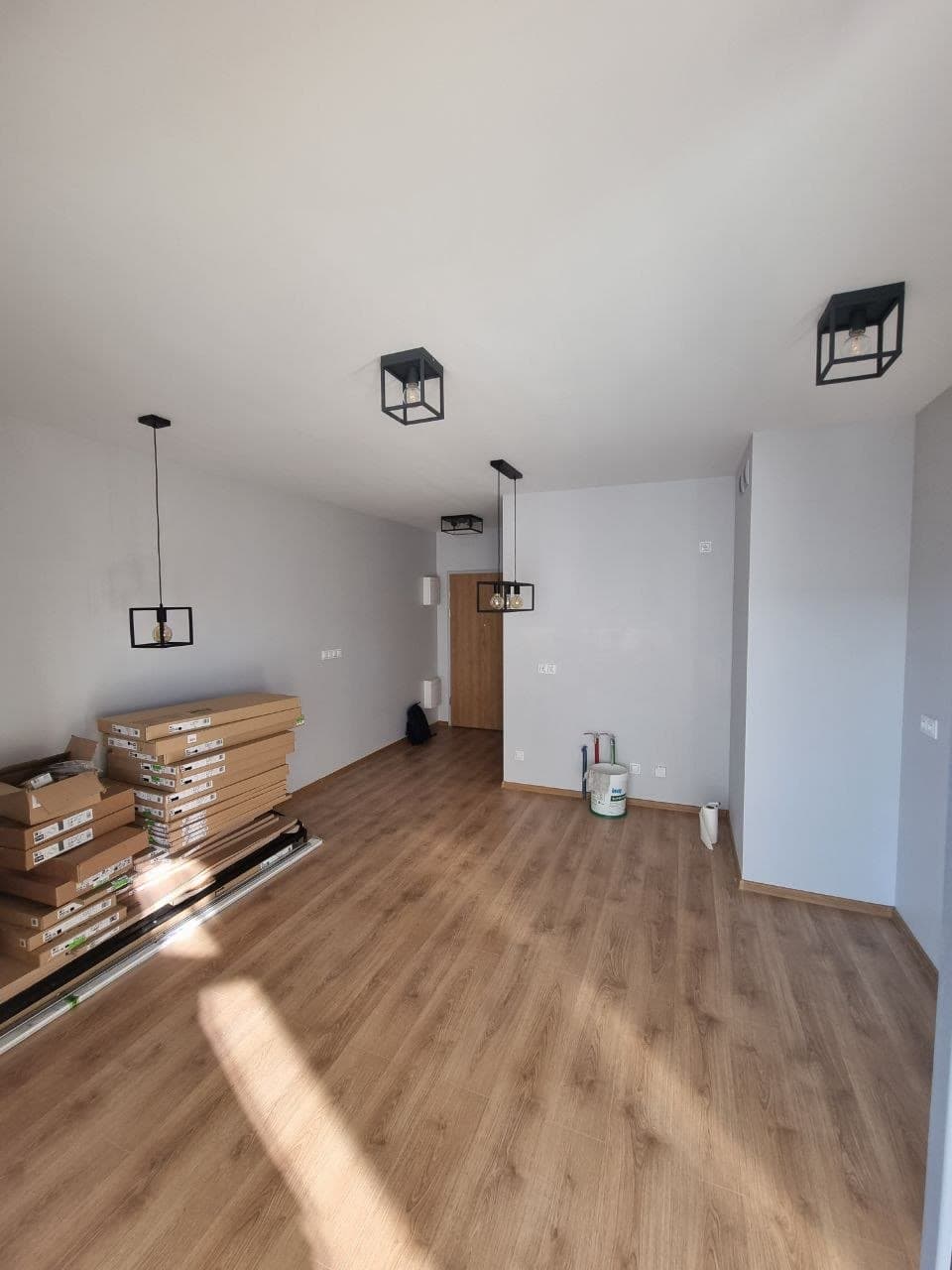 Bright, freshly painted room with wood flooring and modern light fixtures — Calgary interior painting